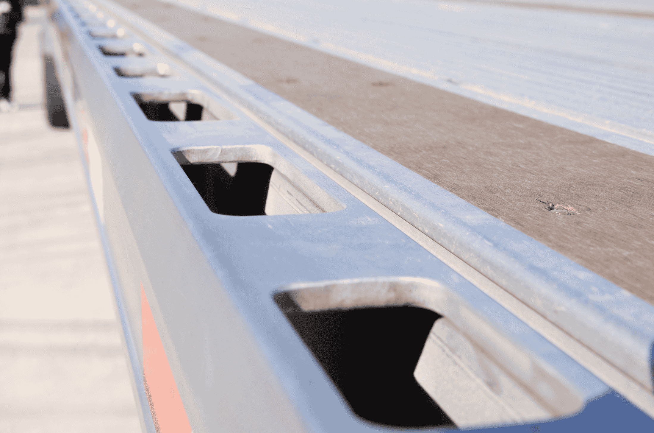 Close-up of the rub rail and side construction of a Hyundai Translead Latitude Flatbed trailer, highlighting its durable design and advanced trailer technology for cargo securement.
